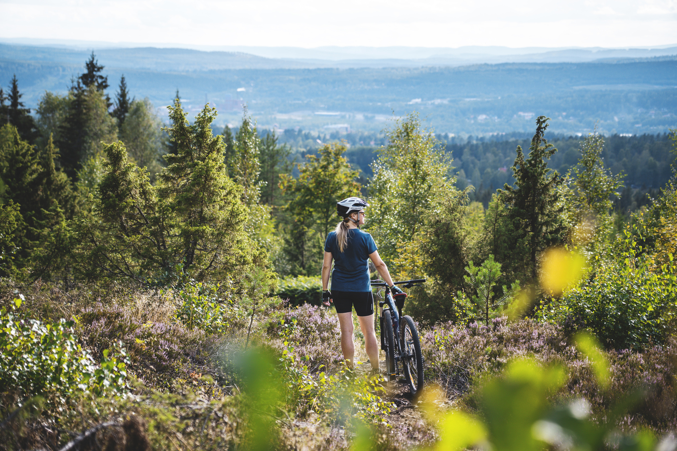 Jente som står ved MTB-sykkelen sin.