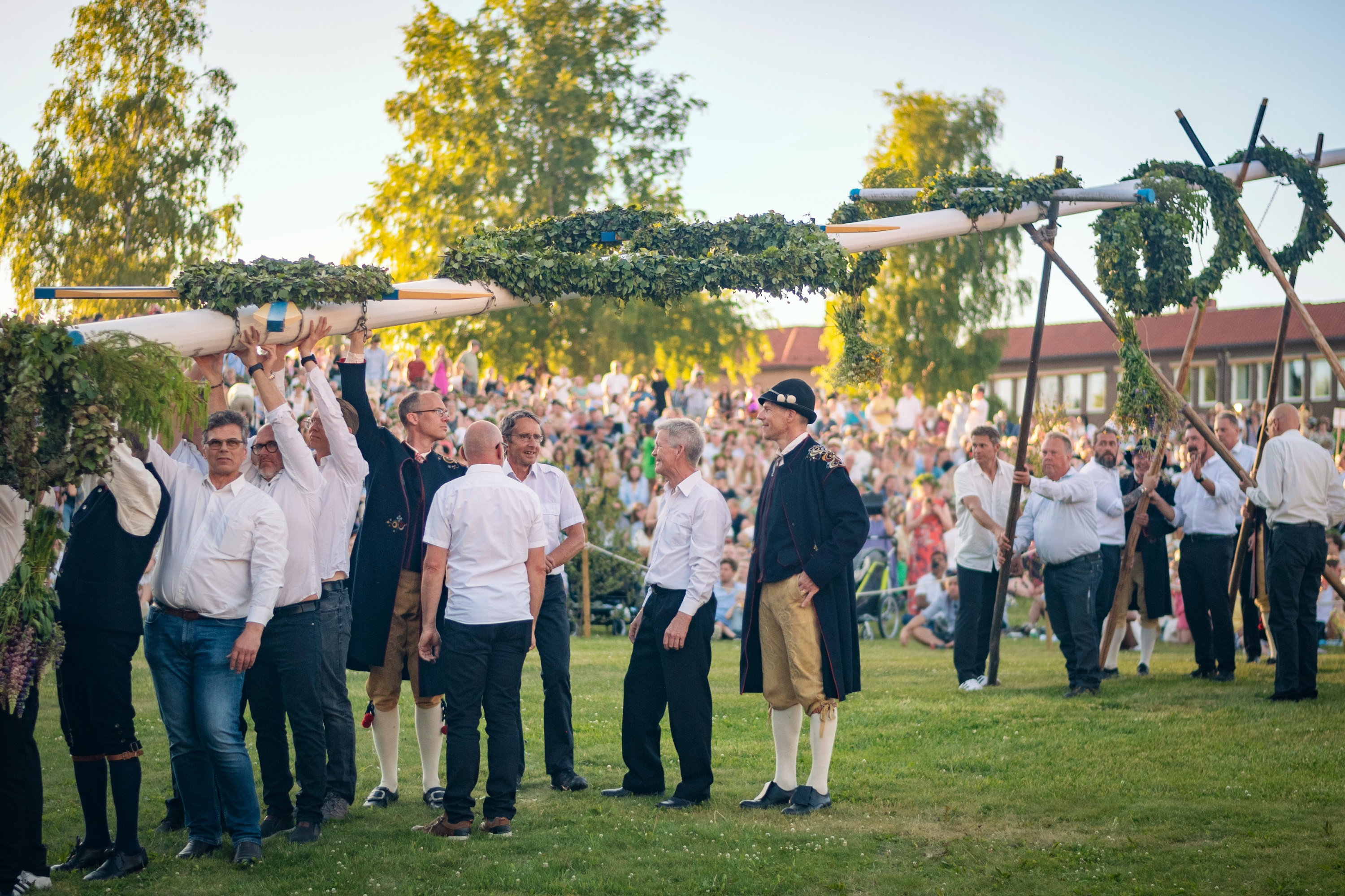 Folk hæver midsommerstangen.