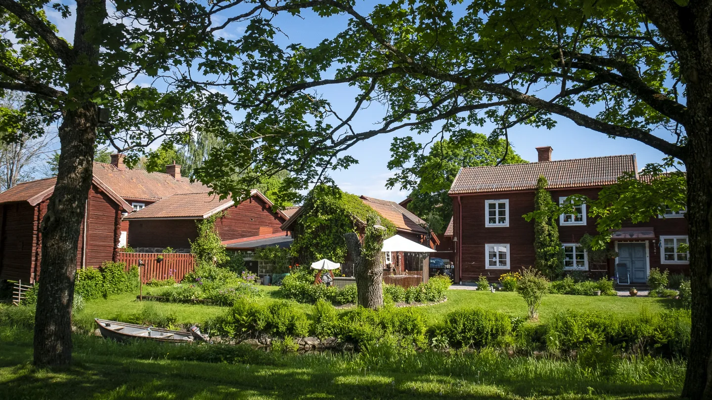 Rote Hütten in einer grünen Landschaft. 